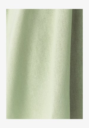 Tissu tissé vert clair avec une texture visible et de doux plis créant des ombres et des reflets.