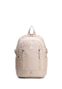 Béžový batoh s několika přihrádkami na zip, bočními kapsami, polstrovanými ramenními popruhy a horním úchytem, stojící vzpřímeně na bílém pozadí.