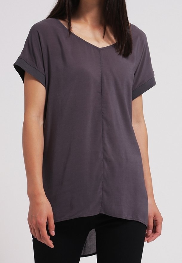 Kortærmet, grå tunika med V-hals, letvægtsstof og en lidt længere bagkant. Har opsmøgte ærmer og en central søm.