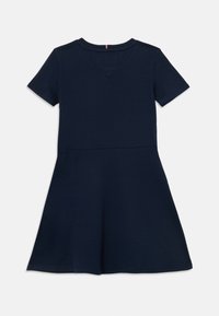 Námornícky krátky rukáv šaty vyrobené z mäkkej tkaniny, s priliehavým živôtikom a rozšírenou sukňou. Obsahuje okrúhly výstrih a jemné švíkové detaily.