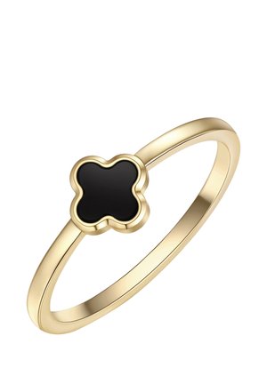 Anillo delgado de oro con una piedra negra en forma de trébol de cuatro hojas, engastada en un bisel elevado sobre un fondo blanco.