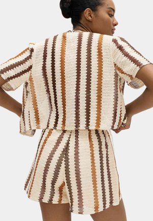 Completo in maglia composto da due pezzi con maniche corte e pantaloncini, caratterizzato da strisce alternate nei colori crema, marrone e ruggine. Tessuto strutturato, vestibilità ampia.