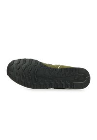 Zapatillas de ante verde con suela de goma negra texturizada. Presenta un patrón de piso duradero para un buen agarre y cordones blancos para un ajuste seguro.