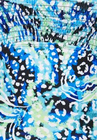 Kangasta monivärinen, jossa on sininen, vihreä ja musta abstrakti kuvio. Pintakuviointi on kerrostettu ja sileä. Suunnittelussa on täpliä ja pyörteitä.