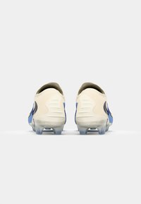 White and blue football boots with a smooth material, a rounded heel, textured accents, and translucent cleats at the base.