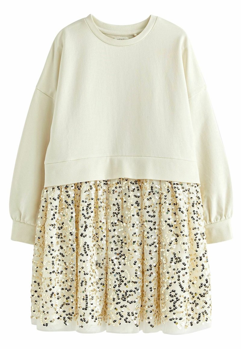 Haut pull en crème avec épaules tombantes et ourlet côtelé, doté d'une jupe superposée en sequins scintillants dorés et noirs sur une base beige.