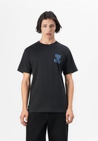 Black cotton t-shirt featuring a blue graphic print "RIDE THE RAILS" on the left chest. Classic crew neck and short sleeves.