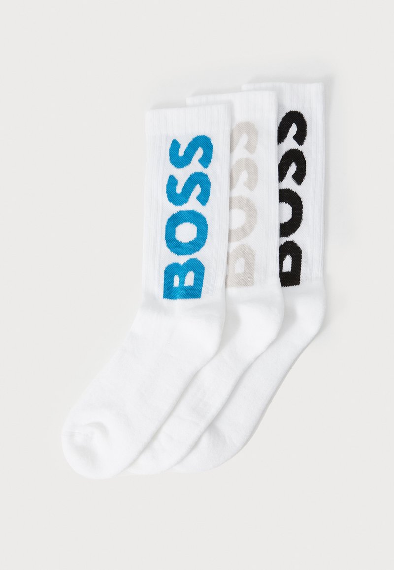Set von weißen Socken mit drei Paaren: eines mit dem blauen Logo "BOSS", eines in Beige und eines in Schwarz. Gerippte Textur und Crew-Länge Design.