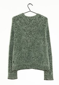 Teksturowany zielony sweter z okrągłym dekoltem, długimi rękawami i luźnym, plecionym wzorem. Wiszący na czarnym metalowym wieszaku.