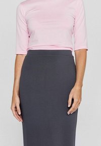 Roze top met korte mouwen in combinatie met een effen grijze rok tot de knie. De top is zacht, terwijl de rok een gladde textuur en een aangesloten ontwerp heeft.