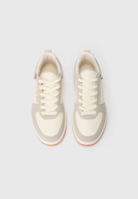 Beige und cremefarbene Sneaker mit Schnürung, aus synthetischen und Wildleder-Materialien, mit feinen Nähten und einem Logodetail an der Seite.