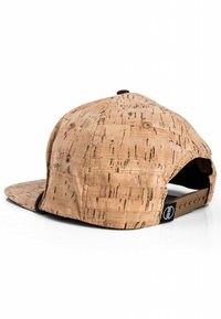 Cork baseball cap with a flat brim, tan color, textured surface, adjustable snapback, and a small logo tag near the back.