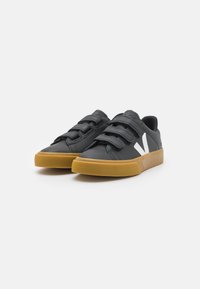 Sneaker nere in pelle con tre fasce in Velcro, logo bianco a contrasto e suola in gomma, caratterizzate da una punta arrotondata e una parte superiore testurizzata.