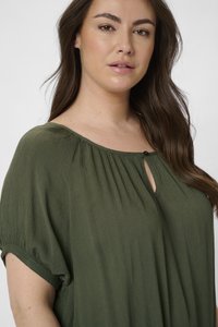 Haut olive décontracté, en tissu texturé avec des manches courtes et un détail de bouton au col.