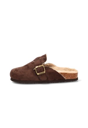 Zapatilla mule de ante marrón con una gran hebilla de latón, forro suave de piel beige y suela con plantillas de corcho sobre fondo blanco.