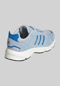 Light blue athletic shoe featuring mesh and suede materials, three blue stripes, padded collar, and white midsole with black outsole.