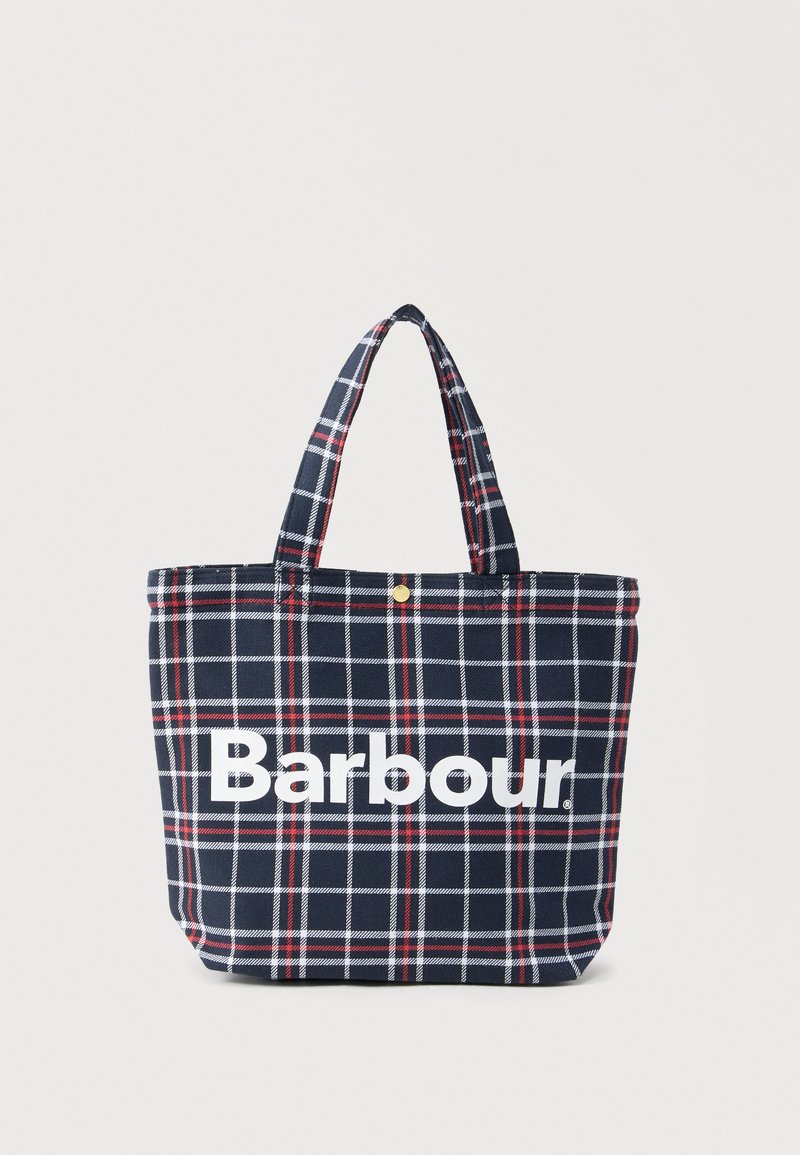 Τσάντα ημέρας σκούρου μπλε με σχέδιο σε άσπρο και κόκκινο καρό, λογότυπο Barbour σε λευκά γράμματα και δύο λουριά ώμου σε ανοιχτό φόντο.