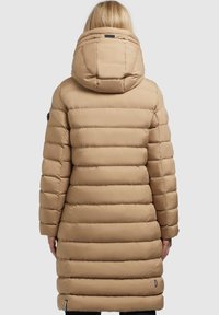 Beige Steppjacke mit Kapuze, langem Schnitt, gesteppte Bereiche und glatter Textur. Schwarze Hardware-Akzente an Schulter und Saum.