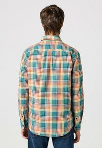 Koszula w kratę w odcieniach teal, pomarańczowym i żółtym; materiał bawełniany; długie rękawy z mankietami na guziki; fałda z tyłu; zaokrąglony dół.