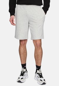 Grijze katoenen shorts in een katoenmix met een elastische tailleband, zijzakken en een klein gekleurd logo op de zoom. Gepaard met zwart-witte sneakers.