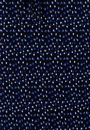 Tessuto blu navy con costine verticali, arricchito da puntini sparsi blu e bianchi. La texture è liscia e leggermente elasticizzata.