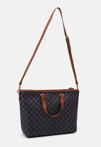 Tummansininen kangaskassi, jossa on kuvioitu pinta, ruskeat nahkahihnat ja irrotettava olkahihna. Ylhäällä vetoketjukiinnitys.