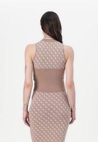 Débardeur en tricot marron avec un corps à motifs, un bustier côtelé et une coupe ajustée. Présente un design géométrique dans des tons plus clairs.