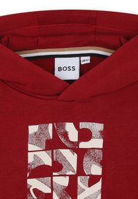 Felpa con cappuccio rossa con stampa logo testurizzata in bianco. Realizzata in un materiale misto cotone, presenta un dettaglio interno del cappuccio a contrasto.