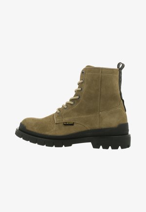 Olivgrüner Wildleder-A ankle-Stiefel mit schwarzer Gummisohle, Schnürung vorne und kontrastierenden Nähten. Verfügt über eine Zuglasche auf der Rückseite für ein einfaches Anziehen.