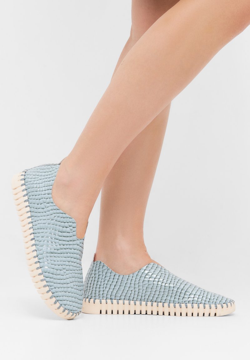 Light blue crocodile-patterned slip-on shoes with a textured upper and contrasting cream-colored rubber sole.