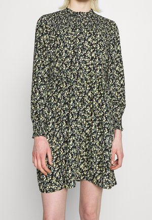 Robe noire à fleurs avec des manches longues, un col froncé et une taille élastique. Elle présente de petites fleurs jaunes et vertes dans un motif éparpillé.