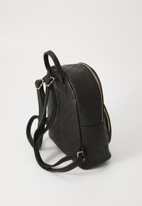 Sac à dos en cuir noir avec motif embossé, accents de fermoir doré, sangles réglables et forme arrondie. Texture lisse et design minimaliste.