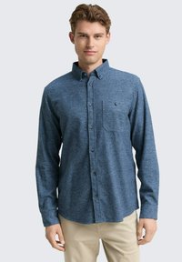Lange mouwen knoopshirt van donkerblauwe stof met een subtiele textuur, met een borstzak en een geknoopte kraag. Perfecte pasvorm.