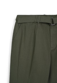 Pantaloni verde oliva con un tessuto strutturato, dotati di una cintura con accessori in argento, tasche laterali e una vestibilità su misura.