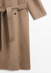 Beige long wool coat with a waist belt, black buttons, and a straight sleeve on a white background.