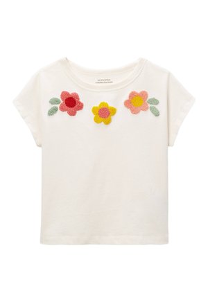 Chemise blanche à manches courtes pour tout-petit avec des motifs floraux en relief rouge, jaune et rose et des feuilles vertes près de l'encolure.