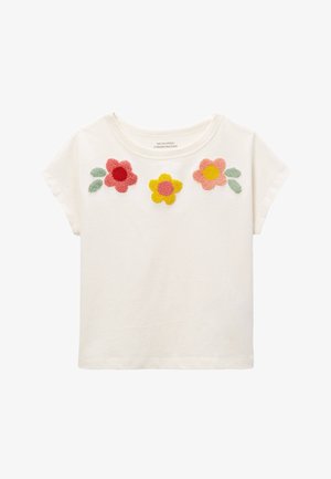 Chemise blanche à manches courtes pour tout-petit avec des motifs floraux en relief rouge, jaune et rose et des feuilles vertes près de l'encolure.
