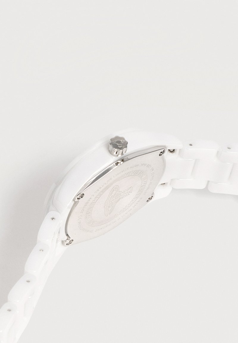 Orologio in ceramica bianca con retro in metallo argento, corona lavorata e cinturino a maglie su uno sfondo chiaro uniforme.