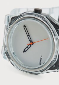 Montre en plastique transparent avec un cadran rond, un cadran blanc, des aiguilles des heures et des minutes noires, et une aiguille des secondes orange. Équipée d'une couronne robuste noire.