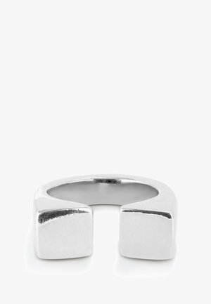 Anillo de metal plateado con un acabado suave y pulido, que presenta dos acentos en forma de cuadrado a cada lado y un diseño de parte posterior abierta.
