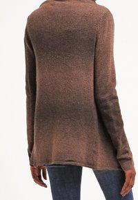 Strickpullover mit einer weichen, strukturierten Oberfläche in einem Farbverlauf von Brauntönen, mit lockerem Schnitt und leicht ausgeflocktem unteren Saum.