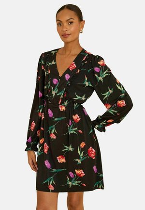 Schwarzes Kleid mit langen Ärmeln, tiefem V-Ausschnitt, floralen Prints in Rot, Pink und Lila, elastischer Taille, Rüschenakzenten entlang des Ausschnitts.