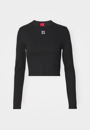 Black long-sleeve cropped top made of smooth fabric, featuring a round neck and white "HUGO" logo at the center chest.