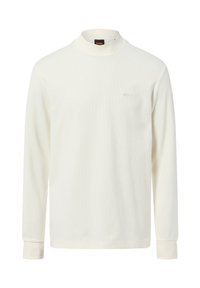 Crème-kleurige blouse met lange mouwen, gemaakt van zachte stof, met een hoge kraag en een klein geborduurd logo op de borst.