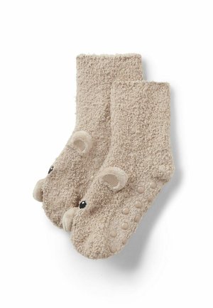 Chaussettes beige douces avec des têtes d'ours sur les orteils et des points antidérapants en caoutchouc sous la semelle pour un confort antidérapant.