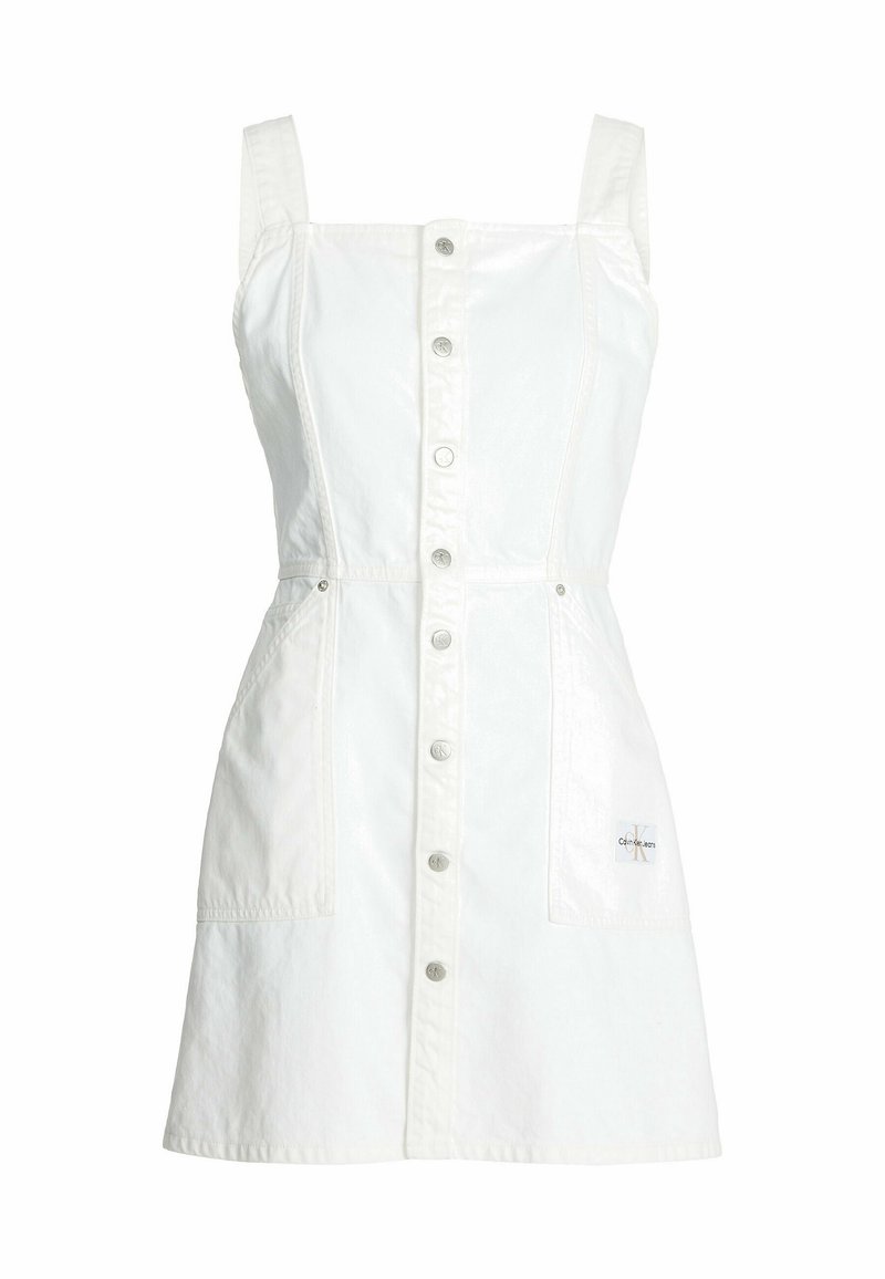 Valkoinen hihaton farkkumekko, jossa on etupainike suljenta, kaksi etutaskua ja Calvin Klein Jeans -logopatchi ala-oikeassa taskussa.