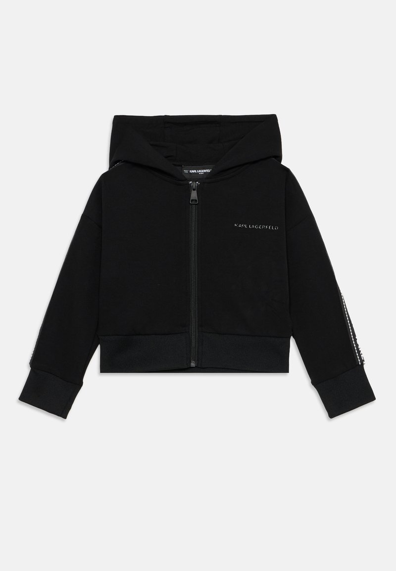 Hoodie cropped preto feito de tecido macio. Apresenta um fecho frontal, capuz e bainha canelada. A manga esquerda tem detalhes decorativos.