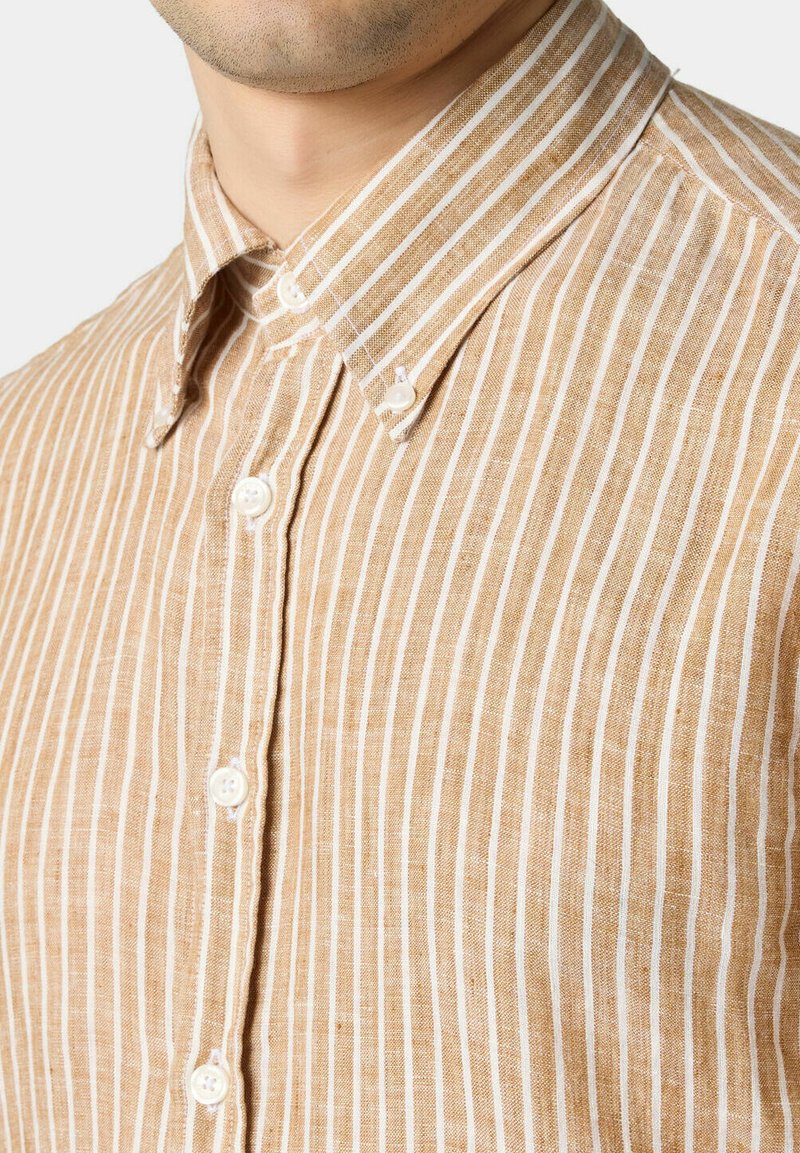 Camicia a righe marrone e bianca, realizzata in tessuto leggero. Presenta un colletto classico e bottoni bianchi lungo la pattina frontale.