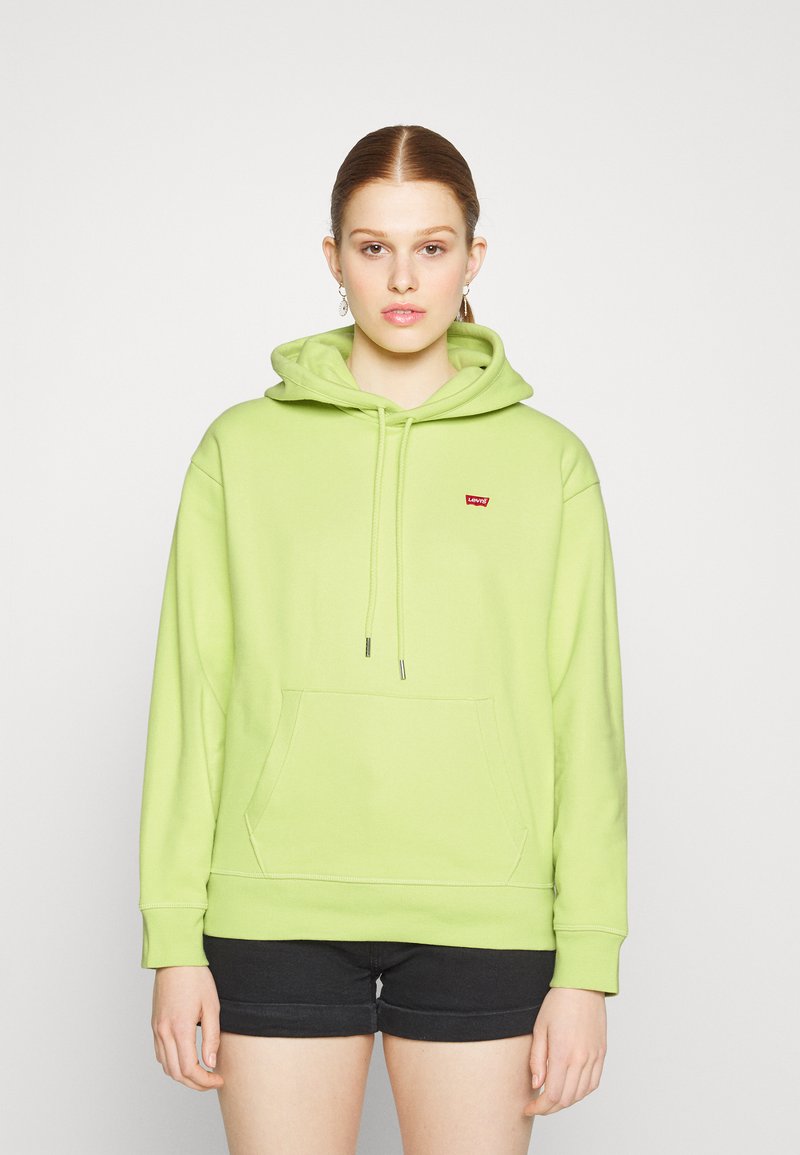Lys grøn hettegenser med frontlomme, snorhette og en liten rød logo. Behagelig tekstur og avslappet passform. Korte svarte shorts.