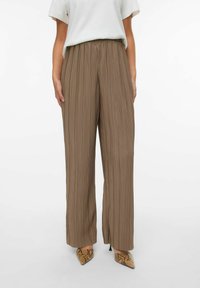 Bruine geplooide wijde broek met een elastische tailleband, gemaakt van lichtgewicht stof. Beschikt over verticale strepen en een soepel ontwerp.